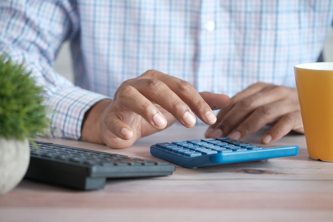 Person using a calculator to review income and mortgage affordability